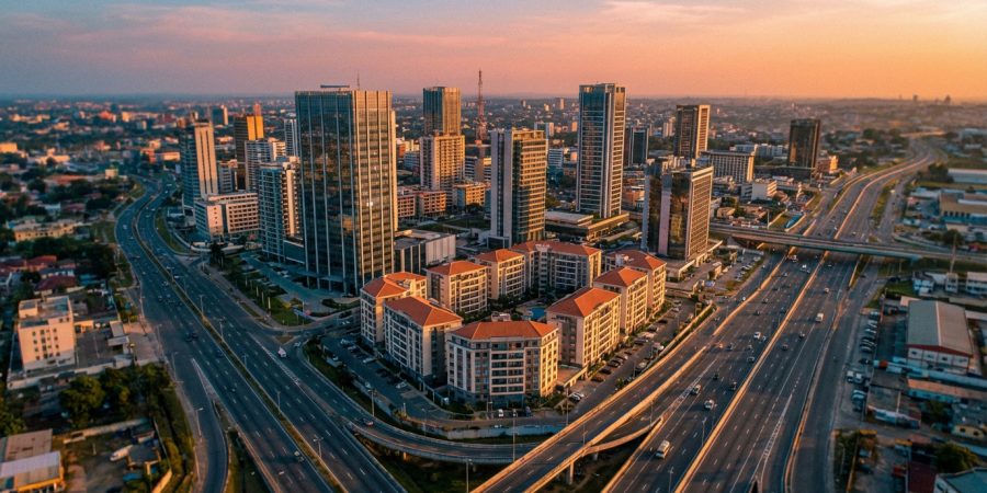 Vue aérienne d'Abidjan au coucher du soleil. Gratte-ciel modernes, échangeurs routiers complexes et bâtiments résidentiels.